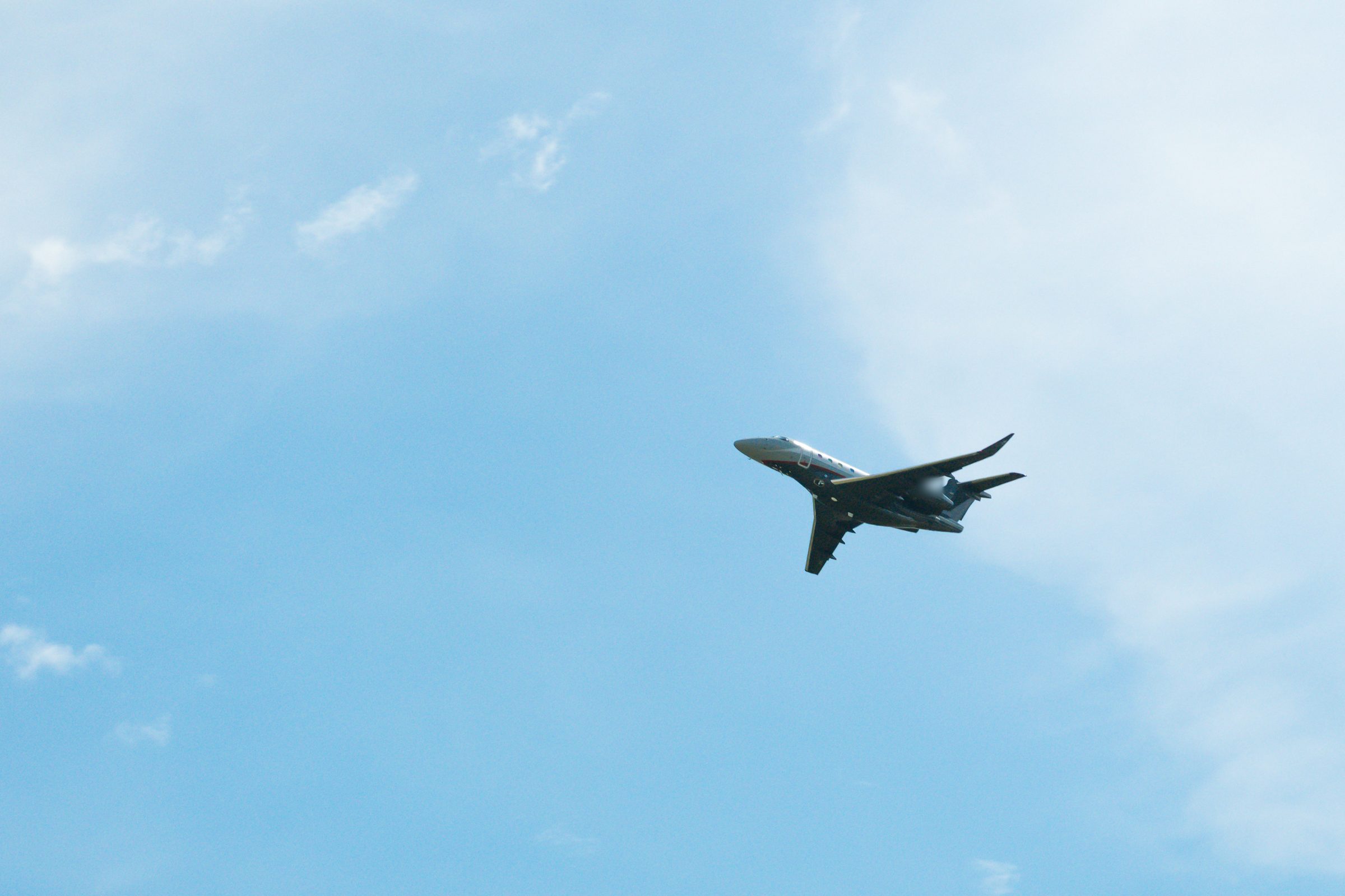 Business jet climbing against a blue sky